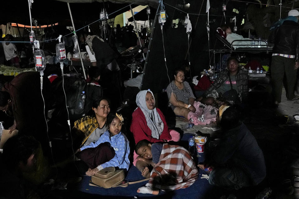 Injured survivors are being treated under a makeshift tent at a hospital in Cianjur, Indonesia late Monday, Nov. 21, 2022. Rescuers on Tuesday struggled to find more bodies from the rubble of homes and buildings toppled by the earthquake that killed a number of people and injured hundreds on Indonesia's main island of Java. (AP Photo/Tatan Syuflana)