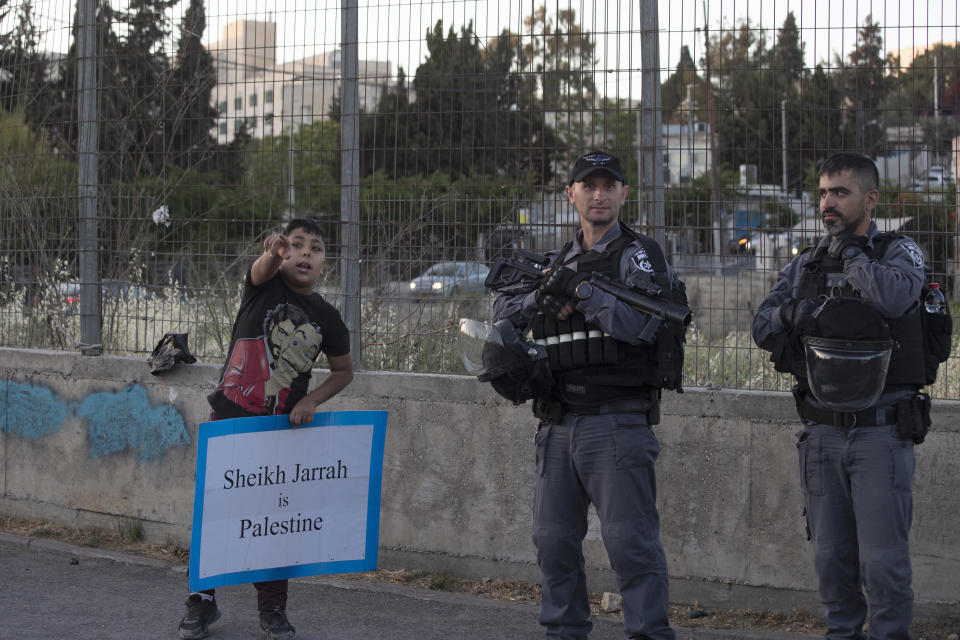 A Palestinian boy speaks to police during a protest against the forcible eviction of Palestinians from their homes in the Sheikh Jarrah neighborhood of east Jerusalem, Friday, May 7, 2021. Dozens of Palestinian families in east Jerusalem are at risk of losing their homes to Jewish settler groups following a decades-long legal battle. The threatened evictions have sparked weeks of protests and clashes in recent days, adding to the tensions in Jerusalem. (AP Photo/Maya Alleruzzo)