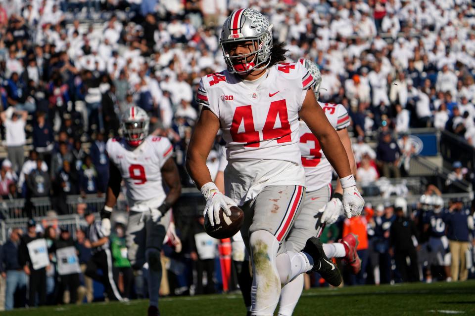 Ohio State defensive end J.T. Tuimoloau runs for a touchdown on his second interception of Penn State quarterback Sean Clifford.