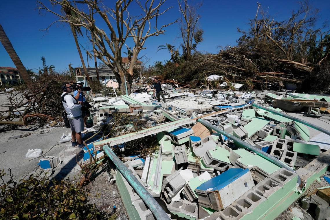 A TV news crew works in debris on Sanibel Island, in the aftermath of Hurricane Ian, Friday, Sept. 30, 2022, on Sanibel Island, Fla. (AP Photo/Steve Helber)