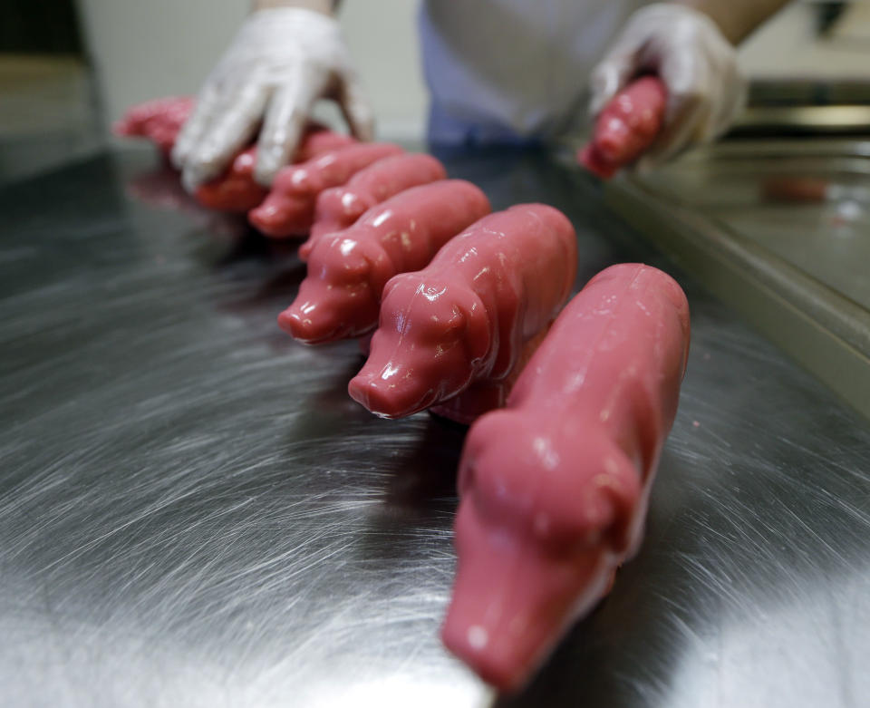 In this Dec. 6, 2012, photo, peppermint pigs are removed from a mold at Saratoga Sweets store in Halfmoon, N.Y. A holiday tradition in upstate New York has a peppermint twist: pig-shaped hard candies are sold with little metal hammers to be smashed at Christmas. (AP Photo/Mike Groll)