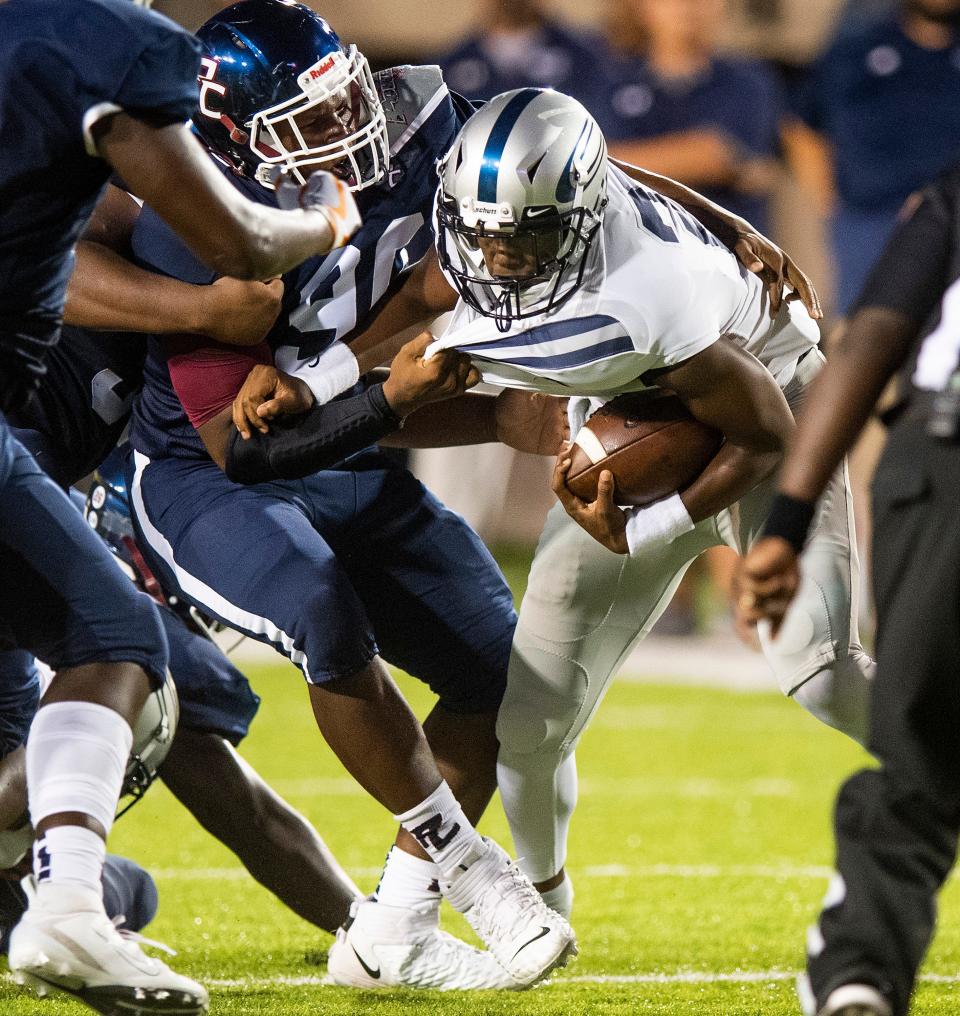 Clay-Chalkville's quarterback Khalib Johnson (2) is stopped by Park Crossing's Renardo Smith (90) at Cramton Bowl in Montgomery, Ala., on Friday September 6, 2019.