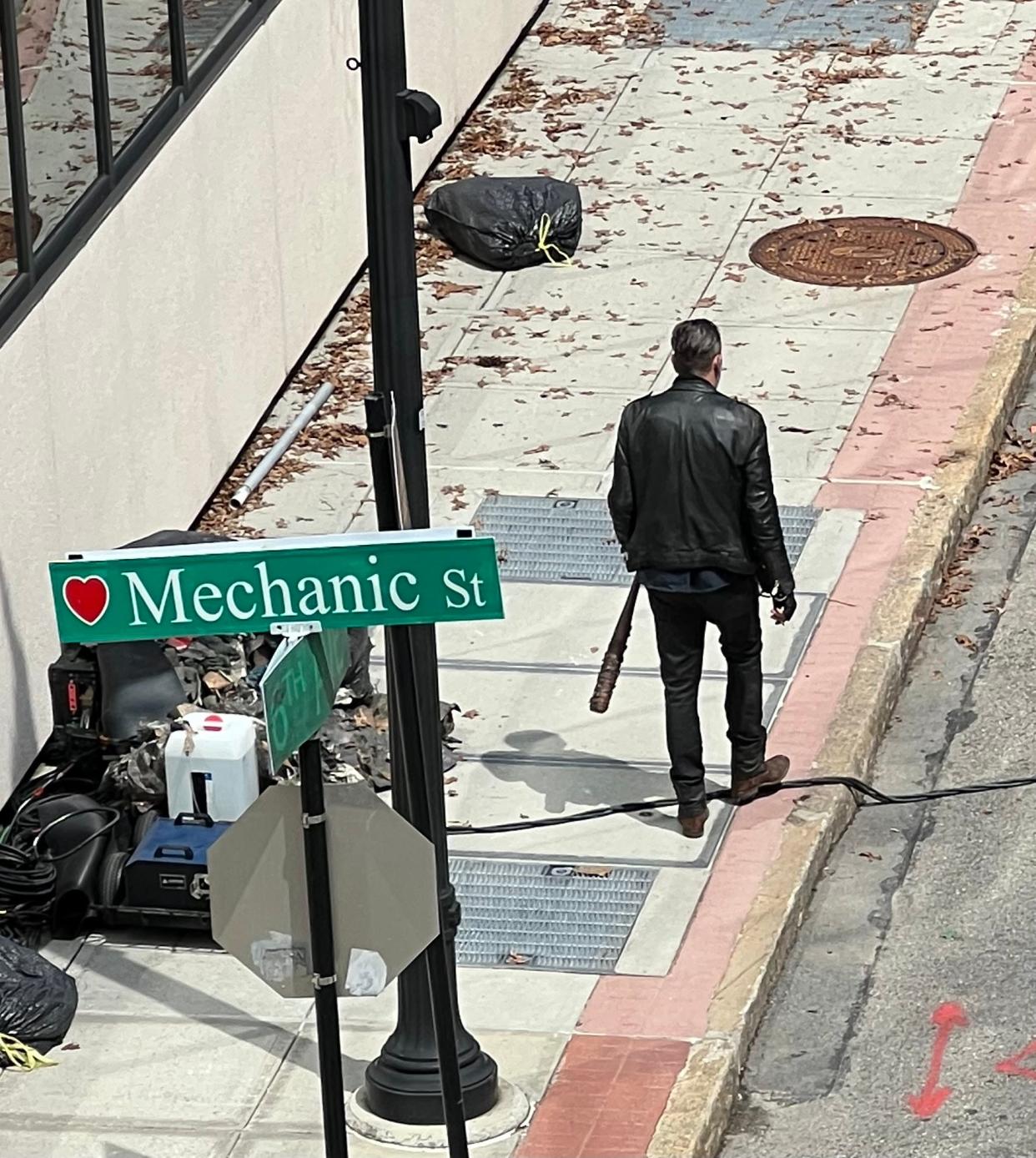 Jeffrey Dean Morgan, who plays Negan on "The Walking Dead" and "The Walking Dead: Dead City," takes a walk with "Lucille," his trusty barbed wire-covered bat, May 6, during a break from filming, at the corner of Norwich and Mechanic streets.