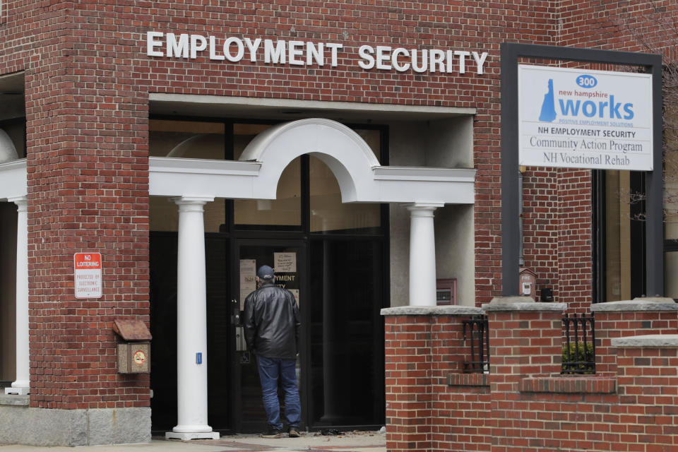 A man reads a note on a locked door at the New Hampshire Employee Security center, which handles unemployment claims, in Manchester, N.H., Thursday, April 16, 2020. Due to the virus outbreak, a note on the office door requested that all claims be handled remotely either on the phone or online. (AP Photo/Charles Krupa)