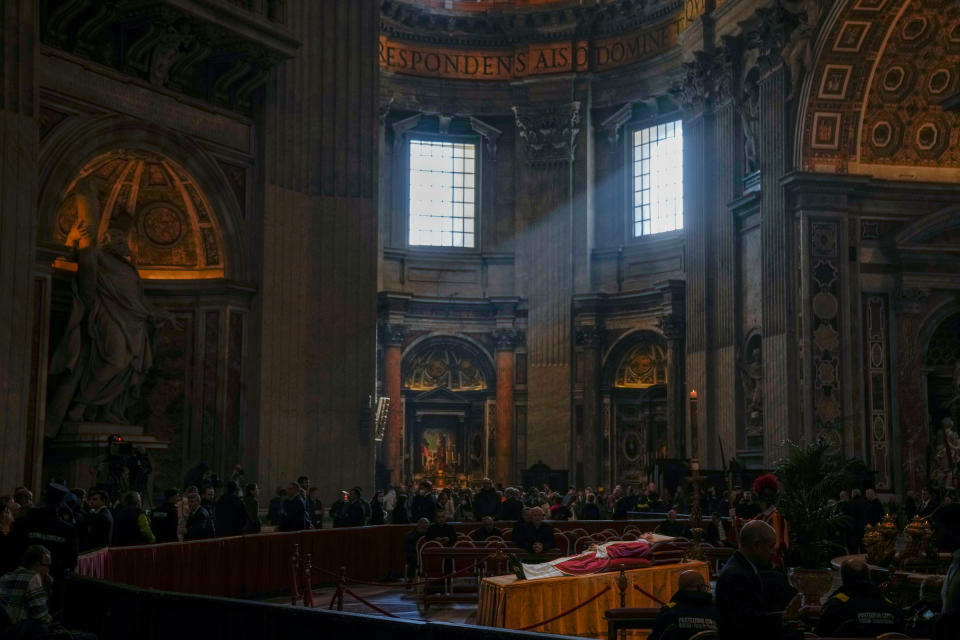 The body of late Pope Emeritus Benedict XVI, his head resting on a pair of crimson pillows, lies in state in St. Peter's Basilica in Vatican City, on Jan. 4, 2023, as thousands of people filed by to pay tribute to the pontiff who shocked the world by retiring a decade ago.<span class="copyright">Antonio Calanni—AP</span>