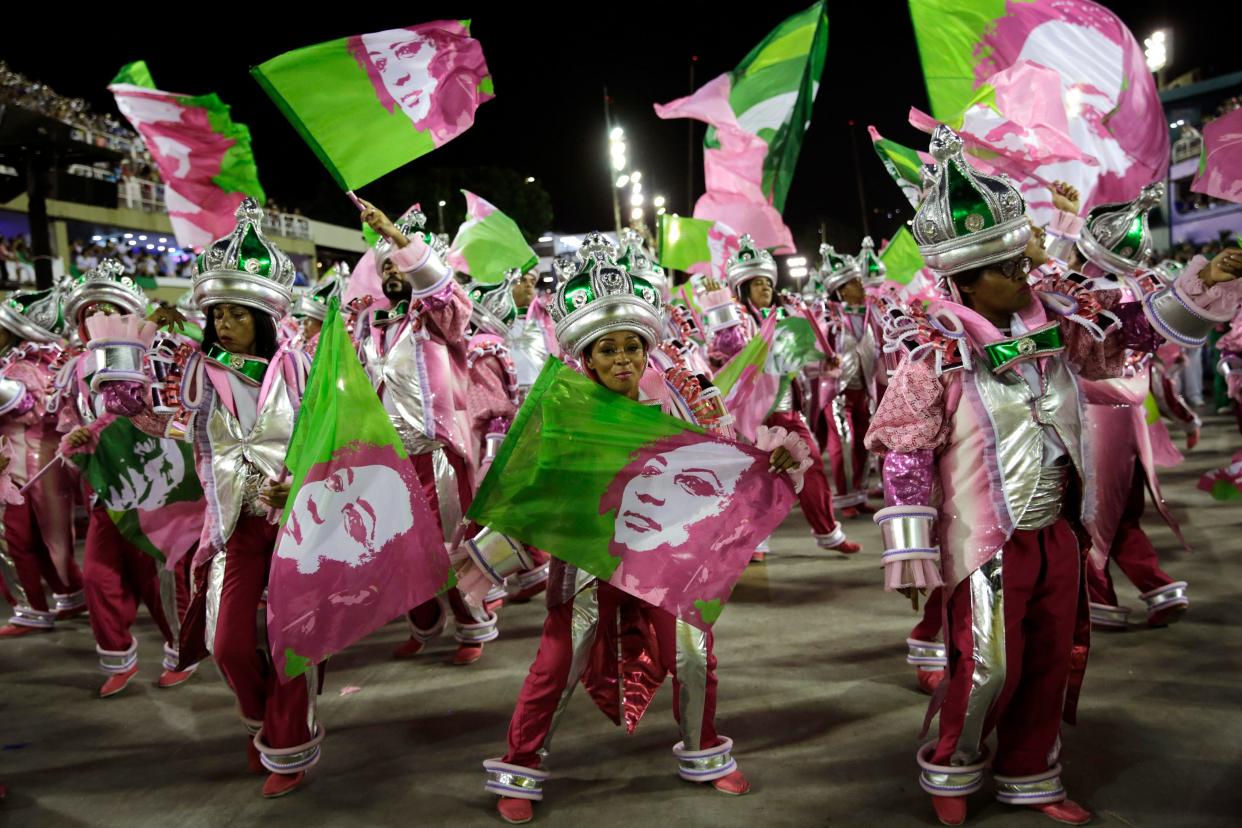 Performers hold flags with an image of slain councilwoman Marielle Franco during the perform of the Mangueira samba school during Carnival celebrations at the Sambadrome in Rio de Janeiro, Brazil, Tuesday, March 5, 2019. (AP Photo/Silvia Izquierdo) ORG XMIT: XSI147