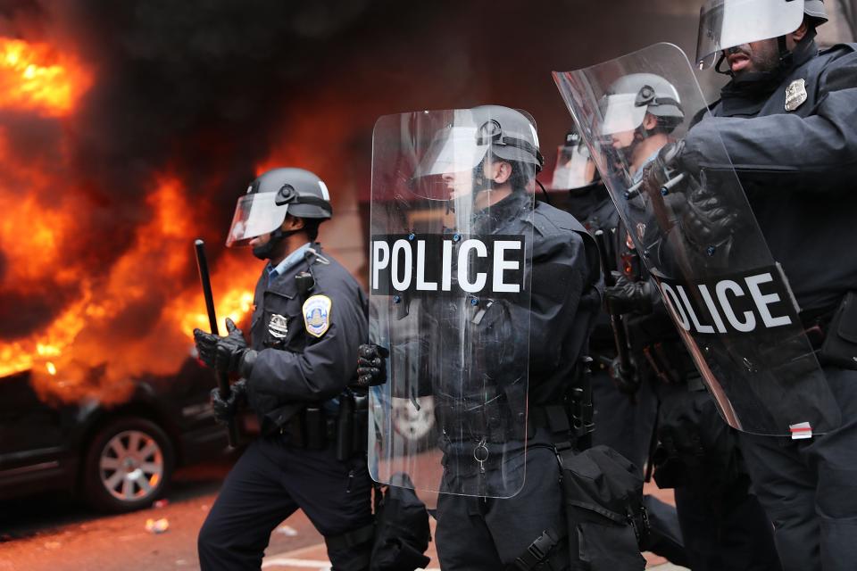 Police in riot gear move towards demonstrators in downtown Washington DC after a limousine was set on fire during Donald Trump’s inauguration. (Getty Images)