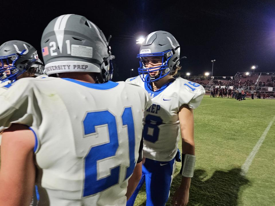 U-Prep senior quarterback Sawyer Hokanson (right) talks to senior wide receiver D.J. Maples in the huddle against Corning on Friday, Sept. 1, 2023.