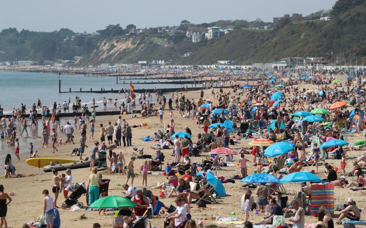 People enjoy the hot weather at Bournemouth beach, Dorset, as Britain is set for a sunny Easter  - PA