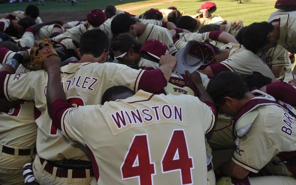 Florida State relief pitcher Jameis Winston (44) joins teammates in prayer after an NCAA college baseball game against Miami on Sunday, March 2, 2014, in Tallahassee, Fla. Florida State won 13-6. (AP Photo/Phil Sears)