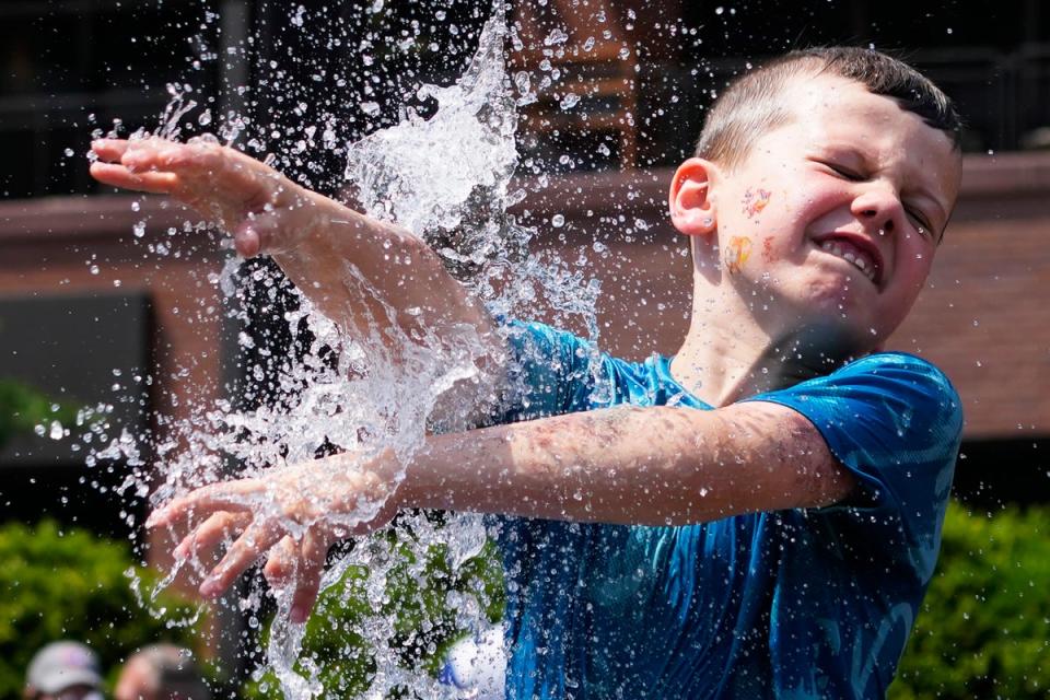 A heat wave is expected to hit much of the US this week from the Midwest to the Northeast. Pictured: a boy cools off at a fountain during hot weather in Chicago on June 16 (AP)