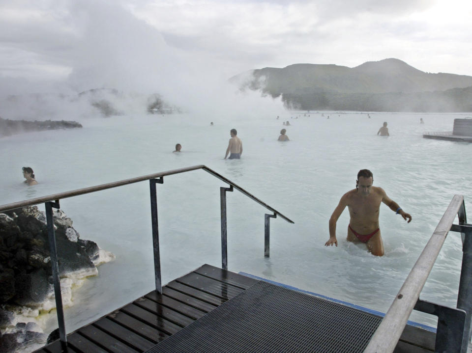 FILE-Bathers enjoy the warm water of the Blue Lagoon on Iceland on Sept.5, 2003. The geothermal spa Blue Lagoon has temporarily closed after a series of earthquakes have put Iceland's southwestern corner on volcanic alert, reaching a state of panic on Thursday when a magnitude 5.0 earthquake occurred just after midnight. (AP Photo/Frank Augstein, File)