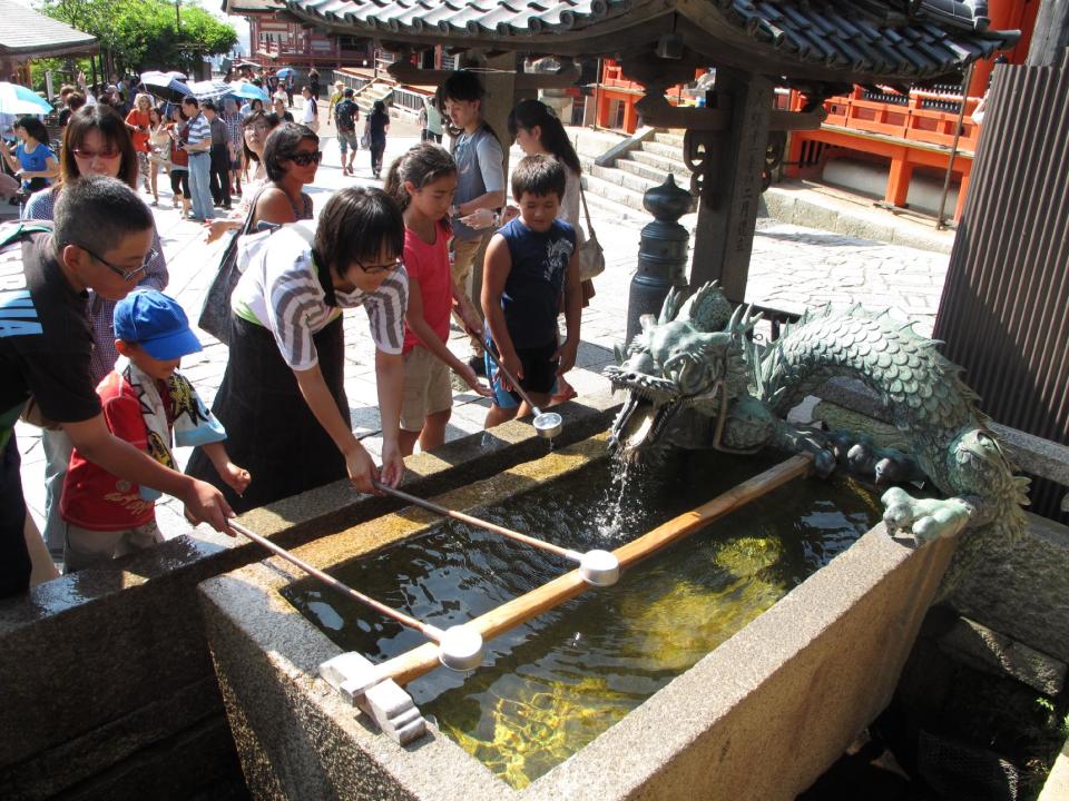 In this August 2012 photo, visitors scoop water from a fountain near the entrance to Kiyomizu Temple in Kyoto, Japan. Such fountains are common at Japanese temples, used to wash hands and cleanse the mouth in a brief purification ritual. (AP Photo/Adam Geller)