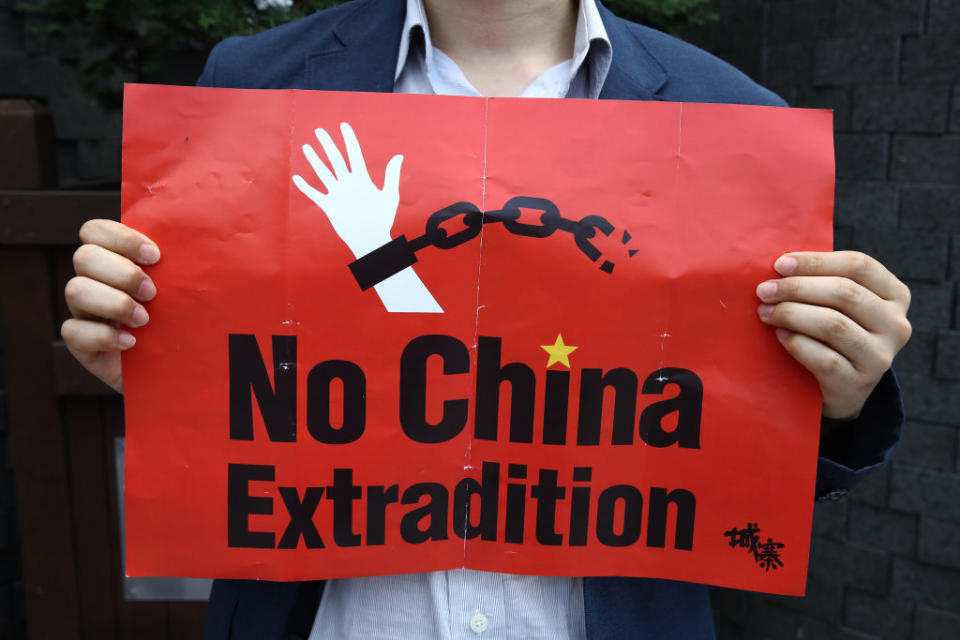 A South Korean man holds a placard during a rally to support Hong Kong's protest over extradition law in front of Chinese embassy on June 17, 2019 in Seoul, South Korea. Source: Getty