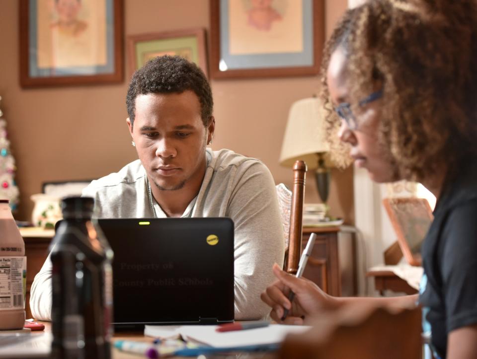 Ty Jackson, 18, studies with his sister Ellie, 15, at their home during the coronavirus pandemic  April 16 in Jacksonville, Fla. They have been participating in online learning since their schools closed because of the virus.