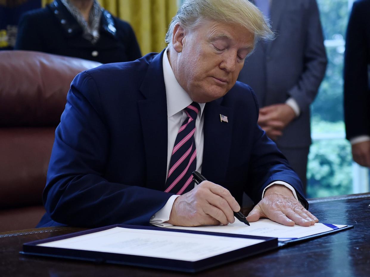 President Donald Trump signs the Paycheck Protection Program and Health Care Enhancement Act in the White House on April 2.