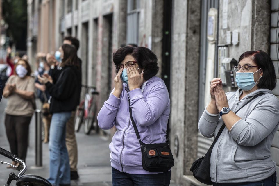 People applaud as they stand outside the house of 23-year-old Italian volunteer Silvia Costanza Romano, in Milan, Italy, Sunday, May, 10, 2020. An Italian aid worker who was kidnapped in Kenya in late 2018 has been freed in Somalia. Italian Premier Giuseppe Conte on Saturday hailed the release of Silvia Romano, who was a 23-year-old volunteer with the humanitarian group Africa Milele when she was abducted in the coastal trading center of Chakama. (AP Photo/Luca Bruno)