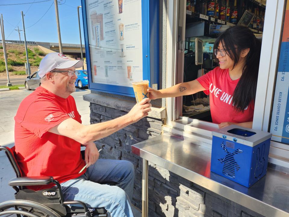 Jason McCoy, Senior Resource Development Director with United Way of Amarillo and Canyon (left) accepts his coffee from Dutch Bros employee (right) at fundraiser benefitting United Way Friday morning at the Dutch Bros Coulter Interstate location.