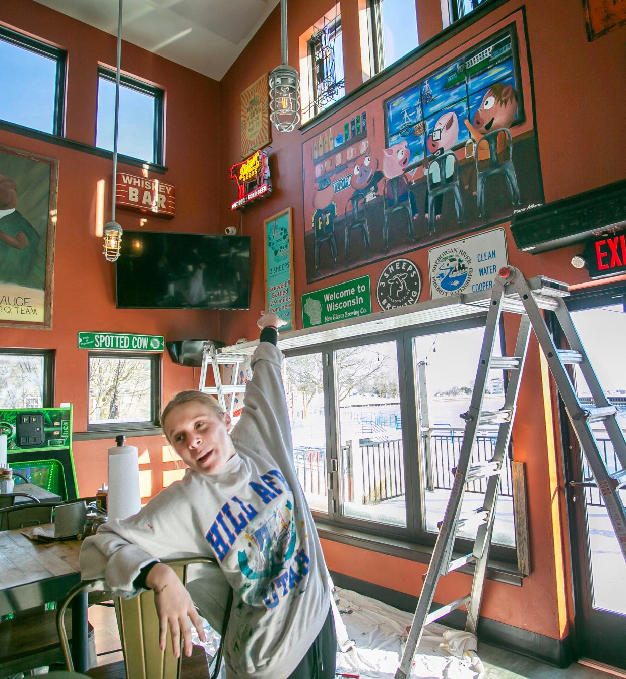 Mary Athorp, of Howards Grove, Wis., explains the creation, Thursday, January 18, 2024, of the new mural at Parker John’s in Sheboygan, Wis.