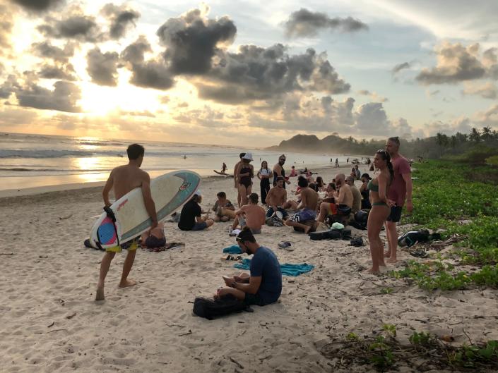 Visitors gather to watch the sunset April 19, 2021, in Playa Guiones, a surfing destination located near the town of Nosara, Costa Rica.