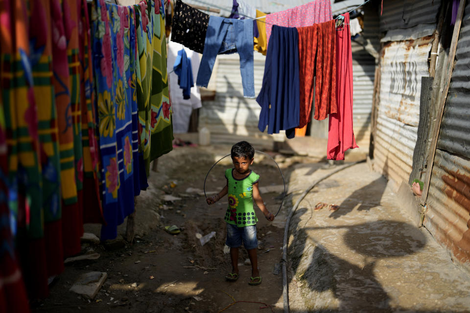 A child plays with a jump rope in a narrow lane of a poor neighborhood in Bengaluru, India, Tuesday, July 19, 2022. In this community, most people are from Assam state, many forced to migrate because of climate change and dreaming of a better future. (AP Photo/Aijaz Rahi)