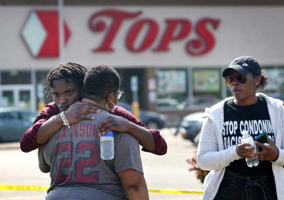 <div class="inline-image__caption"><p>People gathered outside of Tops market embrace on Sunday. Police say the gunman chose it because it was in a Black neighborhood.</p></div> <div class="inline-image__credit">Scott Olson/Getty</div>