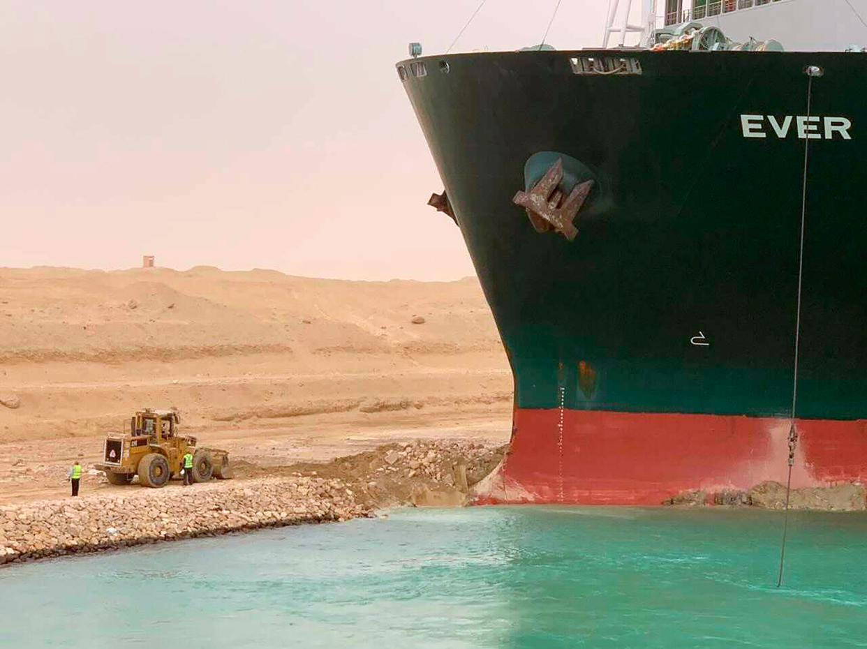 In this photo released by the Suez Canal Authority, a cargo ship named the Ever Given sits with its bow stuck into the wall Wednesday, March 24, 2021, after it became wedged across Egypt’s Suez Canal and blocked all traffic in the vital waterway. An Egyptian official warned Wednesday it could take at least two days to clear the ship.