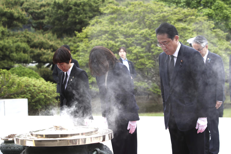 Japanese Prime Minister Fumio Kishida, right, and his wife Yuko, center, pay a silent tribute during a visit to National Cemetery in Seoul, South Korea Sunday, May 7, 2023. The leaders of South Korea and Japan are to meet Sunday for their second summit in less than two months, as they push to bolster cooperation following years of fraught ties over historical issues. (Chung Sung-Jun/Pool Photo via AP)
