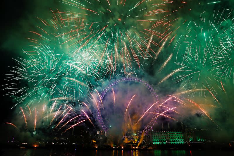 Fireworks explode over the London Eye wheel during New Year celebrations in central London