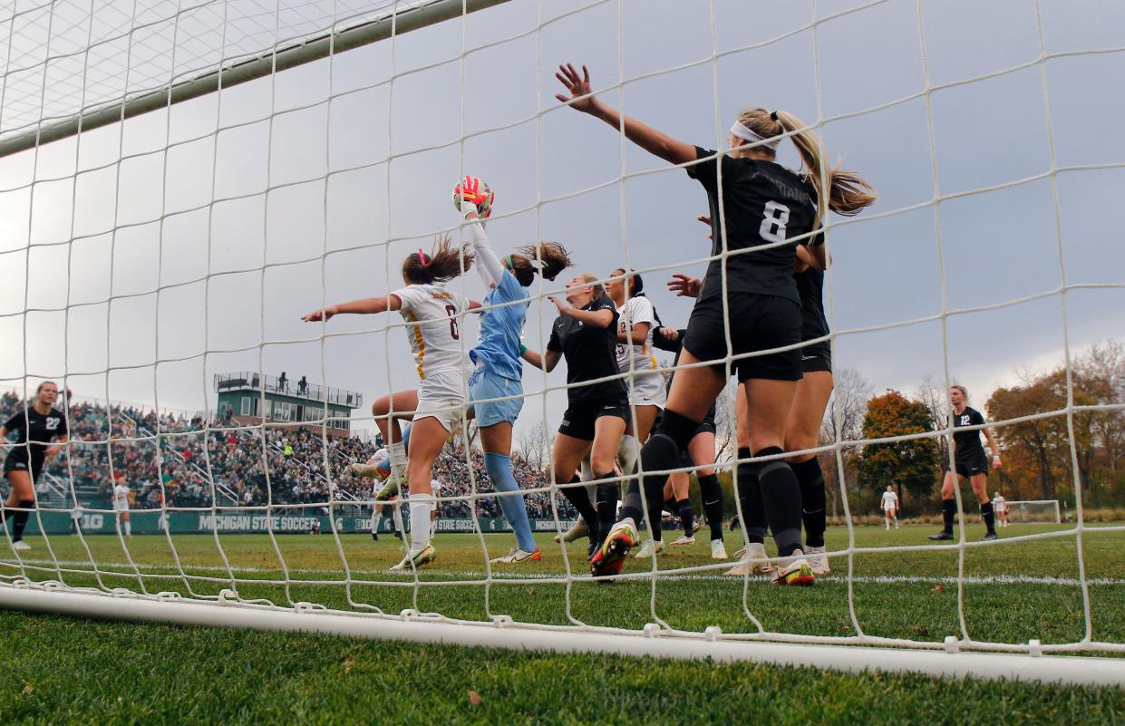 Michigan State's goalkeeper Lauren Kozal, center, pulls in the ball against Minnesota's Sophia Romine, left, Sunday, Oct. 30, 2022, in East Lansing.