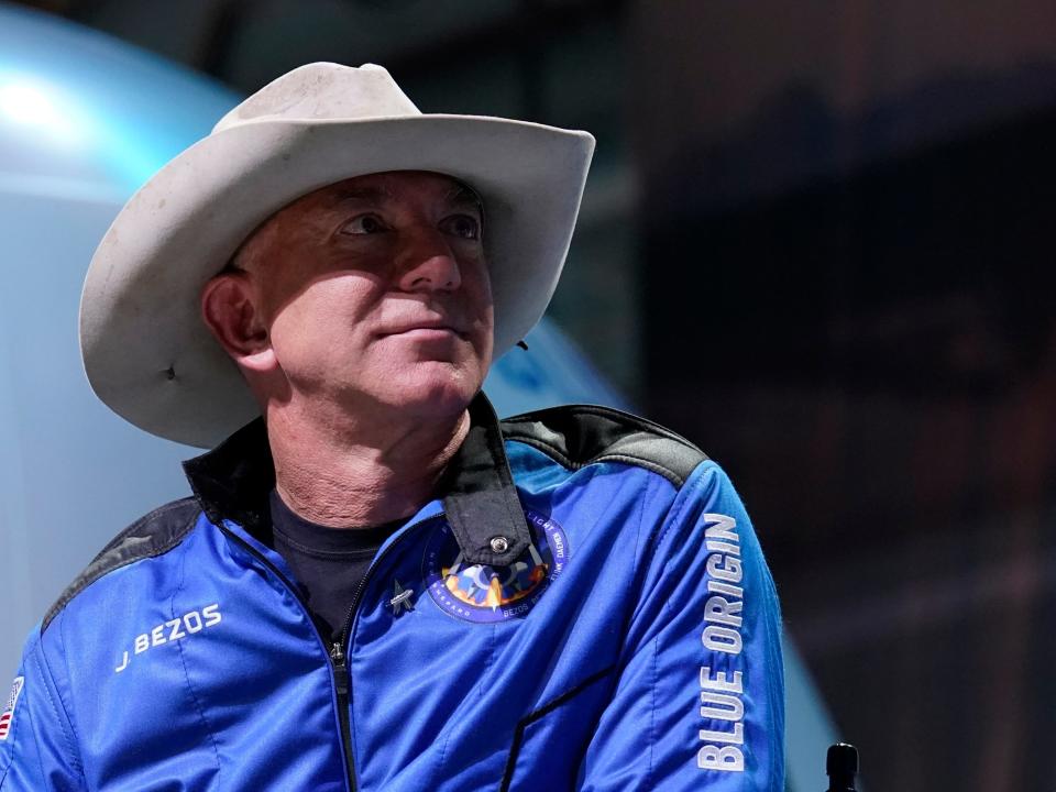 Jeff Bezos wearing a white cowboy hat and a blue jacket with Blue Origin branding.