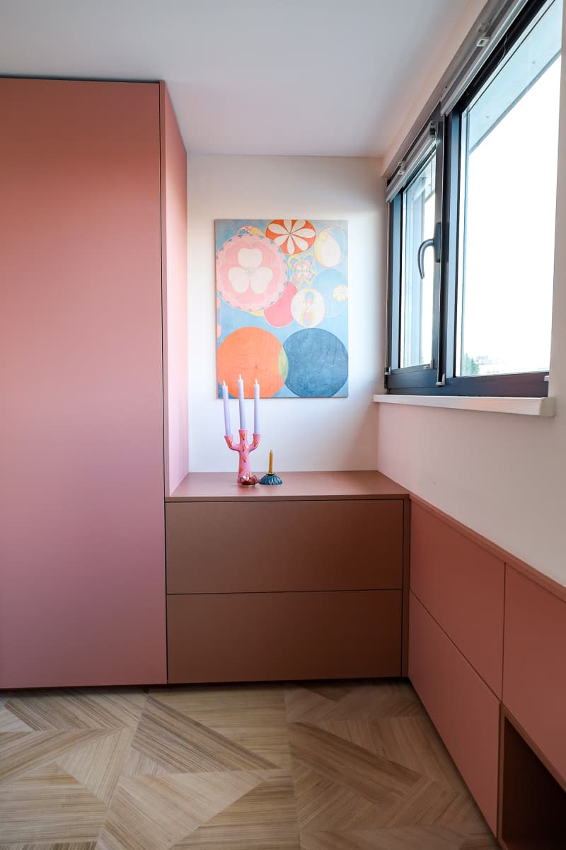 Artwork fills wall space in pastel bedroom.
