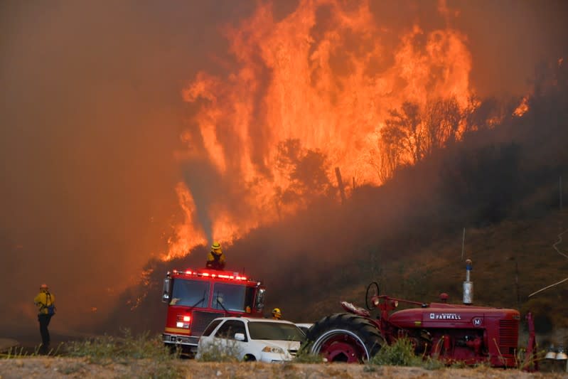 Firefighters arrive to battle the Tick fire, a wind driven wild fire in the hills of Canyon Country north of Los Angeles