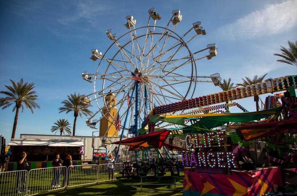 A Ferris wheel and a spinning ride called the 'cliff hanger' are seen in the carnival area during the Taste of Jalisco Festival in Cathedral City, Calif., Saturday, Feb. 4, 2023. 