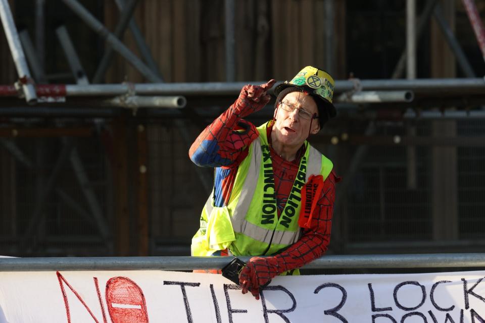 He is dressed in a baggy Spiderman costume and Extinction Rebellion vest (Nigel Howard)