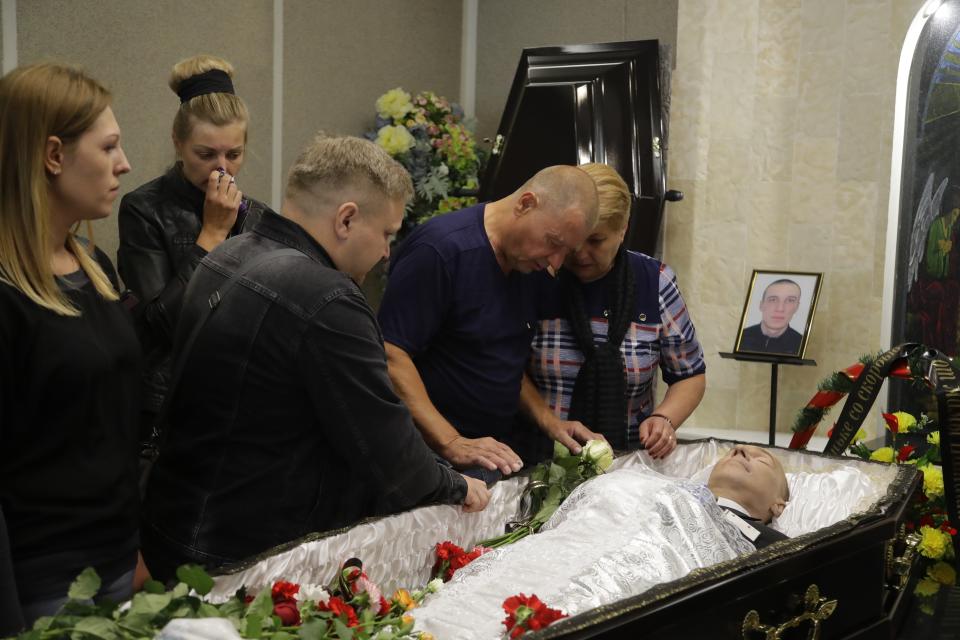 Relatives gather around the coffin of Alexander Taraikovsky, who died amid the clashes protesting the election results, during his funeral in Minsk, Belarus, Saturday, Aug. 15, 2020. Taraikovsky died Monday as demonstrators roiled the streets of the capital Minsk, denouncing official figures showing that authoritarian President Alexander Lukashenko, in power since 1994, had won a sixth term in office. (AP Photo/Sergei Grits)