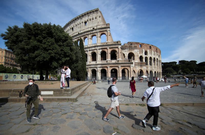 FILE PHOTO: People walk outside the Colosseum, in Rome