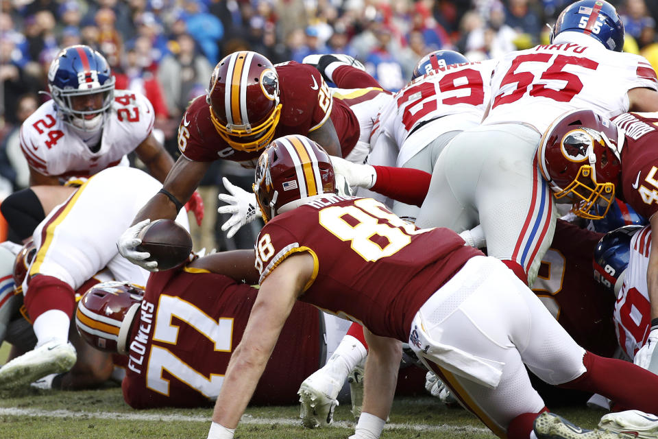 Washington Redskins running back Adrian Peterson (26) dives over a scrum while scoring a touchdown against the New York Giants during the second half of an NFL football game, Sunday, Dec. 22, 2019, in Landover, Md. (AP Photo/Patrick Semansky)