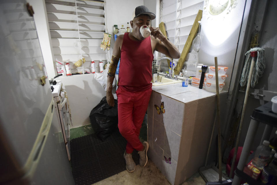 In this early morning Sept. 8, 2018 photo, 56-year-old dialysis patient Elias Salgado drinks a cup of coffee in his kitchen in Vieques as he prepares for his thrice-weekly trip to the Puerto Rican mainland where he receives his treatment. The thrice-weekly trips have taken a toll. Six of the 15 patients who were being flown from Vieques to the Puerto Rican mainland have died in this past year. Advocates insist that the very flights that keep the patients alive have hastened their deaths. (AP Photo/Carlos Giusti)