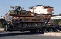 A Turkish military vehicle carrying a tank is pictured in the border town of Akcakale