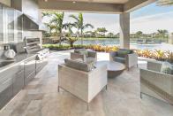 <p>The tropical scenery from this patio makes it an enticing place to sip your morning coffee (or a mimosa). The stainless steel appliances paired with neutral stone ensures a timeless look.</p>