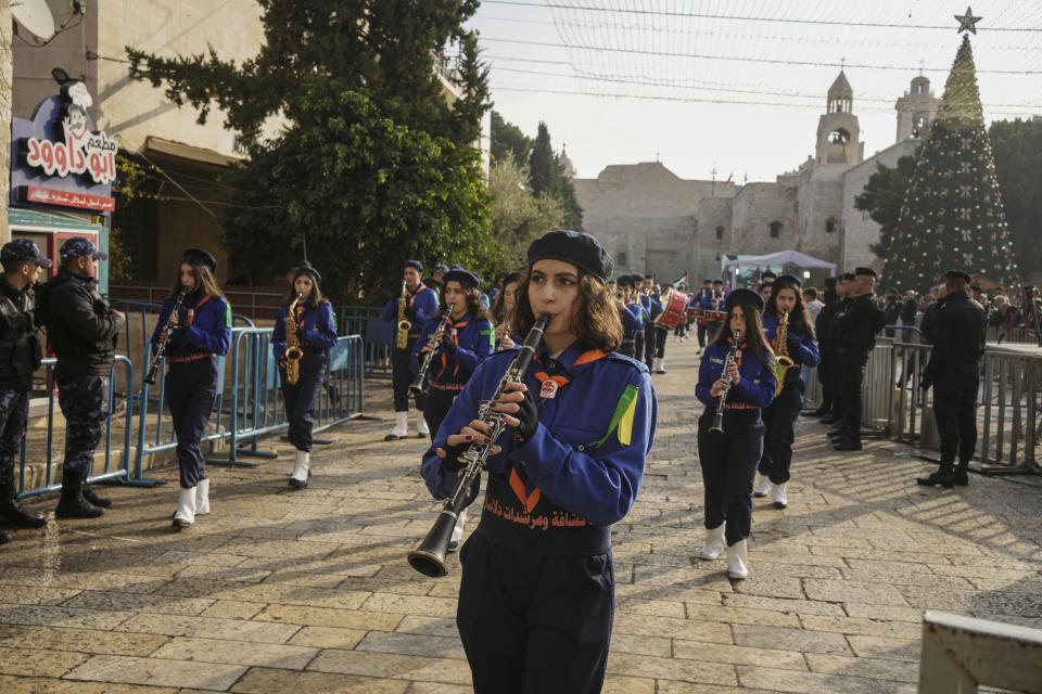 Girls scouts march during Christmas parade in Manger Square, adjacent to the Church of the Nativity, traditionally believed to be the birthplace of Jesus Christ, in the West Bank town of Bethlehem, Saturday , Dec. 24, 2022. (AP Photo/Maya Alleruzzo)