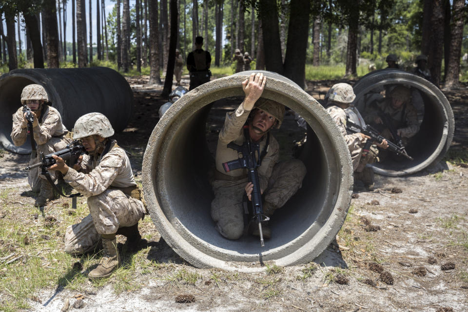 A U.S. Marine Corps recruit checks for a trip-wire around the edge of a culvert pipe during basic warrior training at the Marine Corps Recruit Depot, Wednesday, June 28, 2023, in Parris Island, S.C. (AP Photo/Stephen B. Morton)