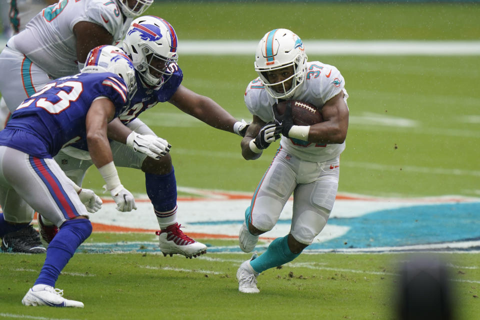 Miami Dolphins running back Myles Gaskin (37) runs the ball A Buffalo Bills strong safety Micah Hyde (23) attempts to stop him, during the first half of an NFL football game, Sunday, Sept. 20, 2020 in Miami Gardens, Fla. (AP Photo/Wilfredo Lee)