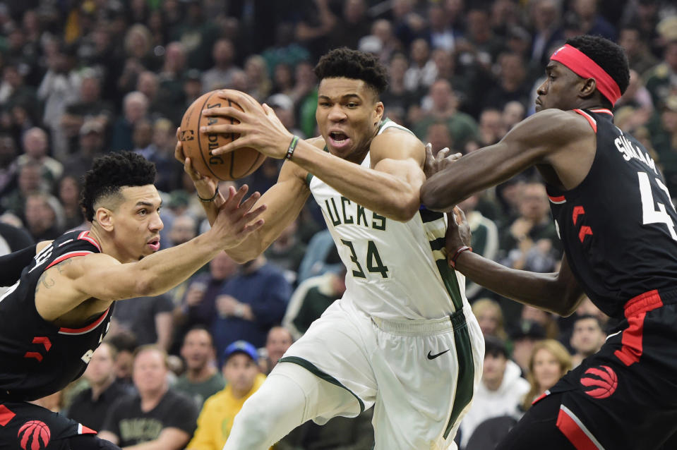 Milwaukee Bucks forward Giannis Antetokounmpo (34) drives between Toronto Raptors guard Danny Green (14) and forward Pascal Siakam (43) during the first half of Game 2 of the NBA basketball playoffs Eastern Conference finals, Friday, May 17, 2019, in Milwaukee. (Frank Gunn/The Canadian Press via AP)