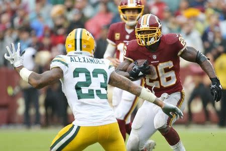 Sep 23, 2018; Landover, MD, USA; Washington Redskins running back Adrian Peterson (26) carries the ball as Green Bay Packers cornerback Jaire Alexander (23) defends in the third quarter at FedEx Field. The Redskins won 31-17. Mandatory Credit: Geoff Burke-USA TODAY Sports