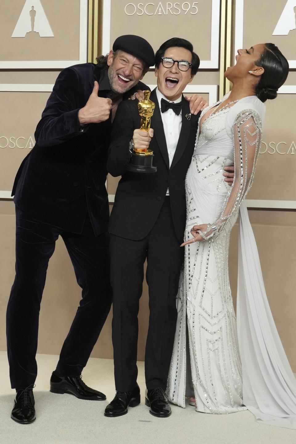 Ke Huy Quan, center, winner of the award for best performance by an actor in a supporting role for "Everything Everywhere All At Once" poses with Troy Kotsur, left, and Ariana DeBose in the press room at the Oscars on Sunday, March 12, 2023, at the Dolby Theatre in Los Angeles. (Photo by Jordan Strauss/Invision/AP)