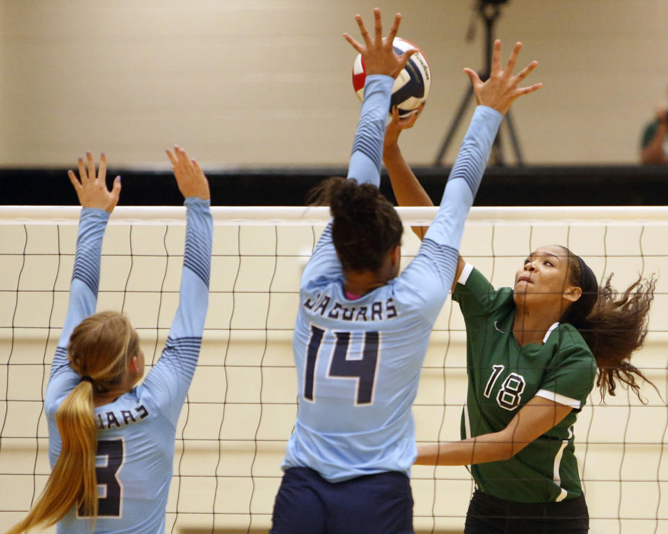 FILE - Reagan's Kyla Waiters, right, spikes the ball past Johnson defenders during a Texas District 26-6A high school volleyball match in San Antonio, Texas, in this Friday, Sept. 22, 2017, file photo. Oregon State leaders are suing to block disclosure of details about an investigation of abuse allegations in their volleyball program, even as they tout a refreshed mission for transparency in wake of their president’s resignation over the handling of sexual-misconduct cases at another school. “I’m guessing there’s something in those records that they don’t want out,” said Dorina Waiters, whose daughter, Kyla, left Oregon State after a year on the volleyball team triggered depression that led to suicidal thoughts. (Ron Cortes/The San Antonio Express-News via AP, File)