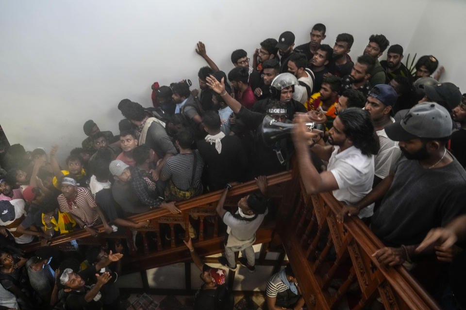 Protesters react after storming the Sri Lankan Prime Minister Ranil Wickremesinghe's office, demanding he resign after president Gotabaya Rajapaksa fled the country amid economic crisis in Colombo, Sri Lanka, Wednesday, July 13, 2022. Rajapaksa fled on a military jet on Wednesday after angry protesters seized his home and office, and appointed Prime Minister Ranil Wickremesinghe as acting president while he is overseas. Wickremesinghe quickly declared a nationwide state of emergency to counter swelling protests over the country's economic and political collapse. (AP Photo/ Photo/Rafiq Maqbool)