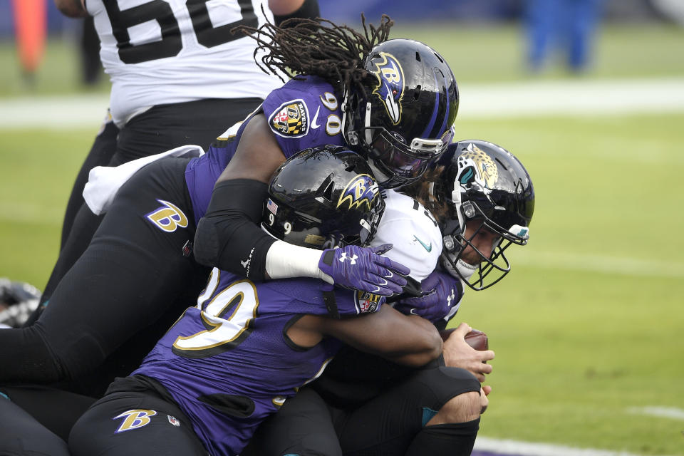 Jacksonville Jaguars quarterback Gardner Minshew II, right, is sacked for a safety by Baltimore Ravens linebacker Pernell McPhee (90) and linebacker Matthew Judon (99) during the first half of an NFL football game, Sunday, Dec. 20, 2020, in Baltimore. (AP Photo/Nick Wass)